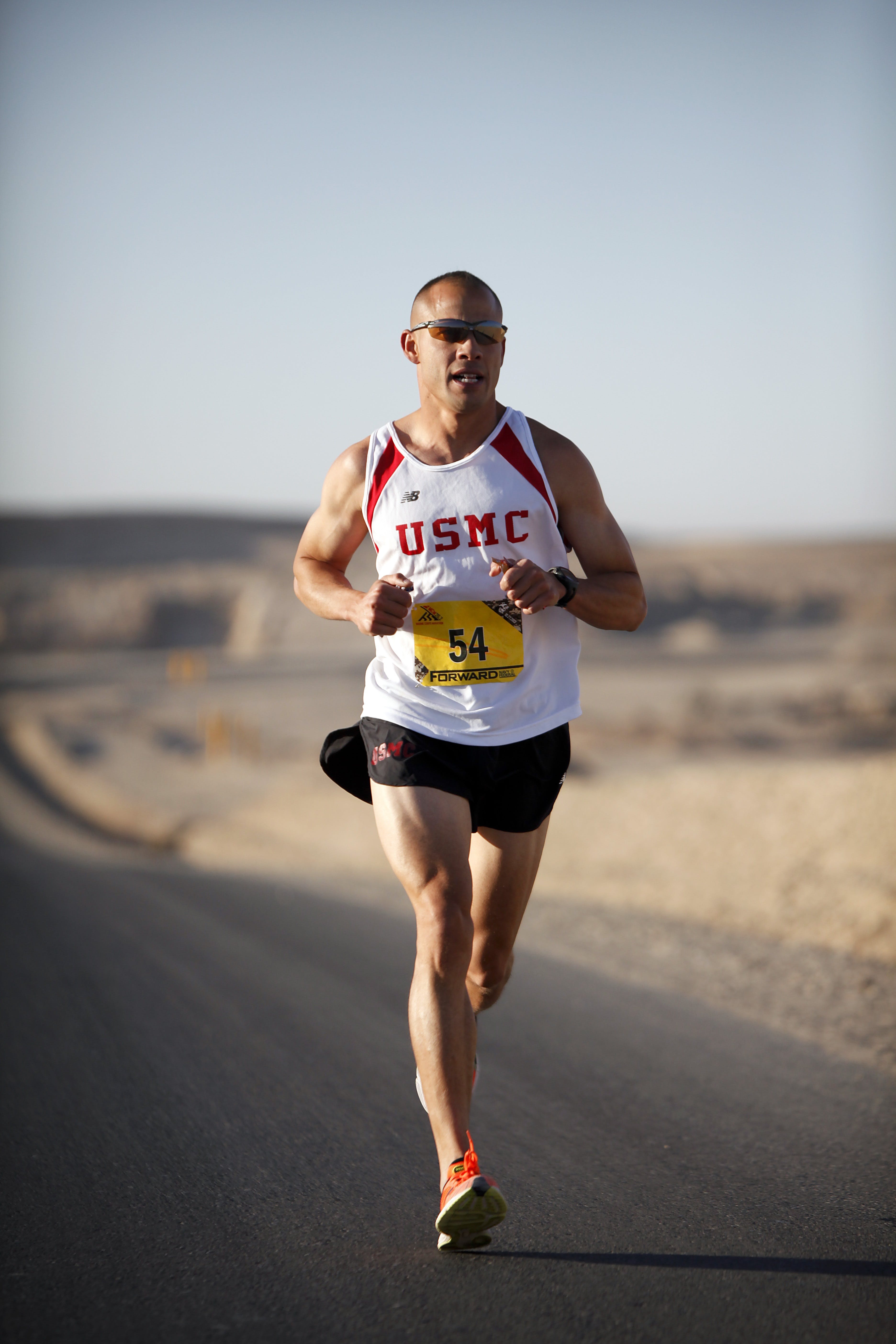 An image showcasing essential running gear laid out neatly, including running shoes, moisture-wicking clothing, a hydration pack, and a GPS running watch.